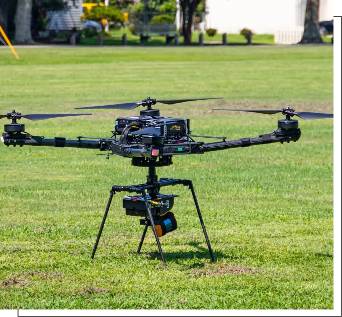 A black and silver helicopter is in the grass