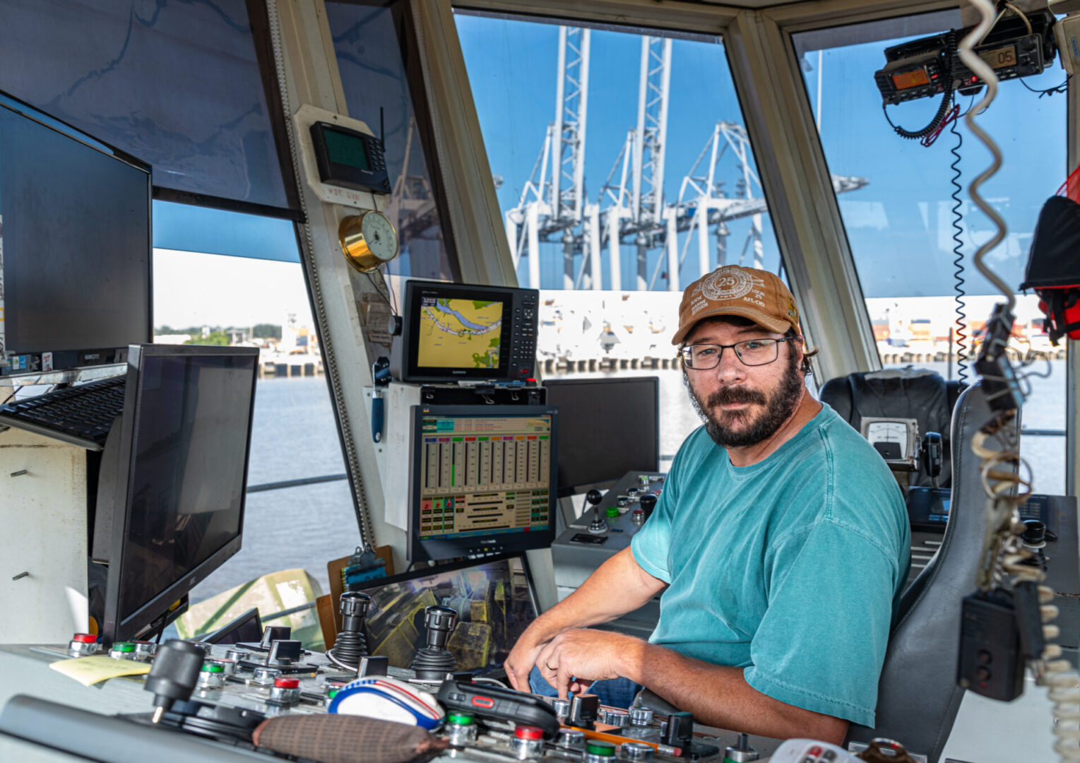 A man sitting at the helm of a boat.