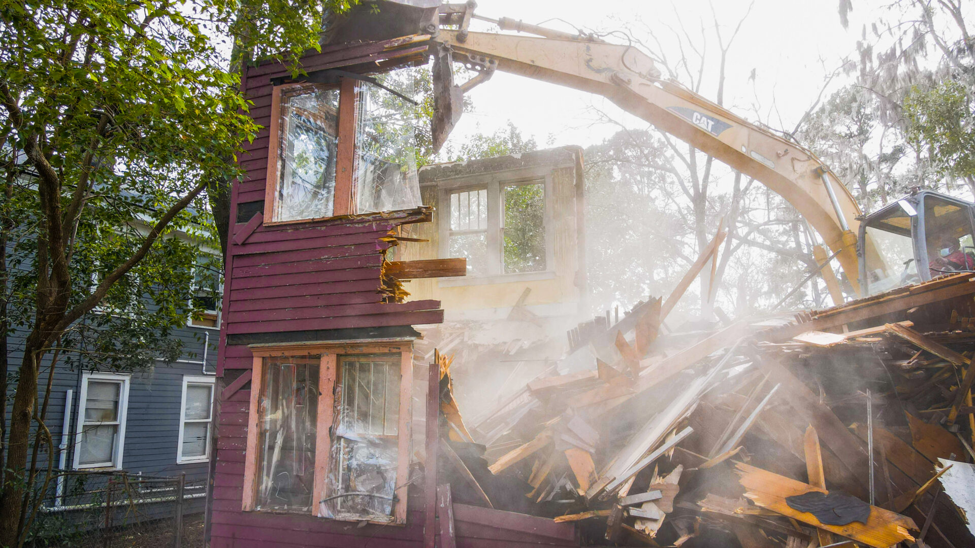 A house being demolished with an excavator.