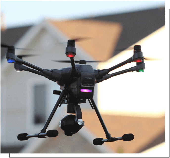 A black and silver camera flying in the air