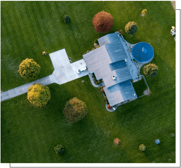 A house with a blue roof in the middle of a green field.