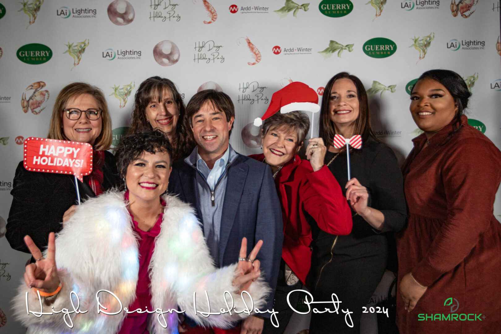 Professional event photographer capturing a corporate event with branded signage and guest engagement moments.