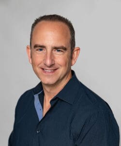 Professional corporate headshot with clean white wall background, ideal for websites, directories, and presentations. corporate photography and videos