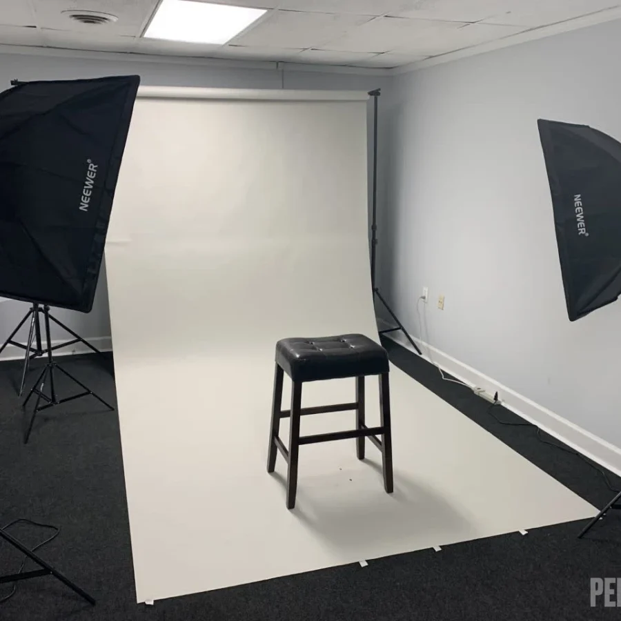 A photo studio with a stool and two lights.